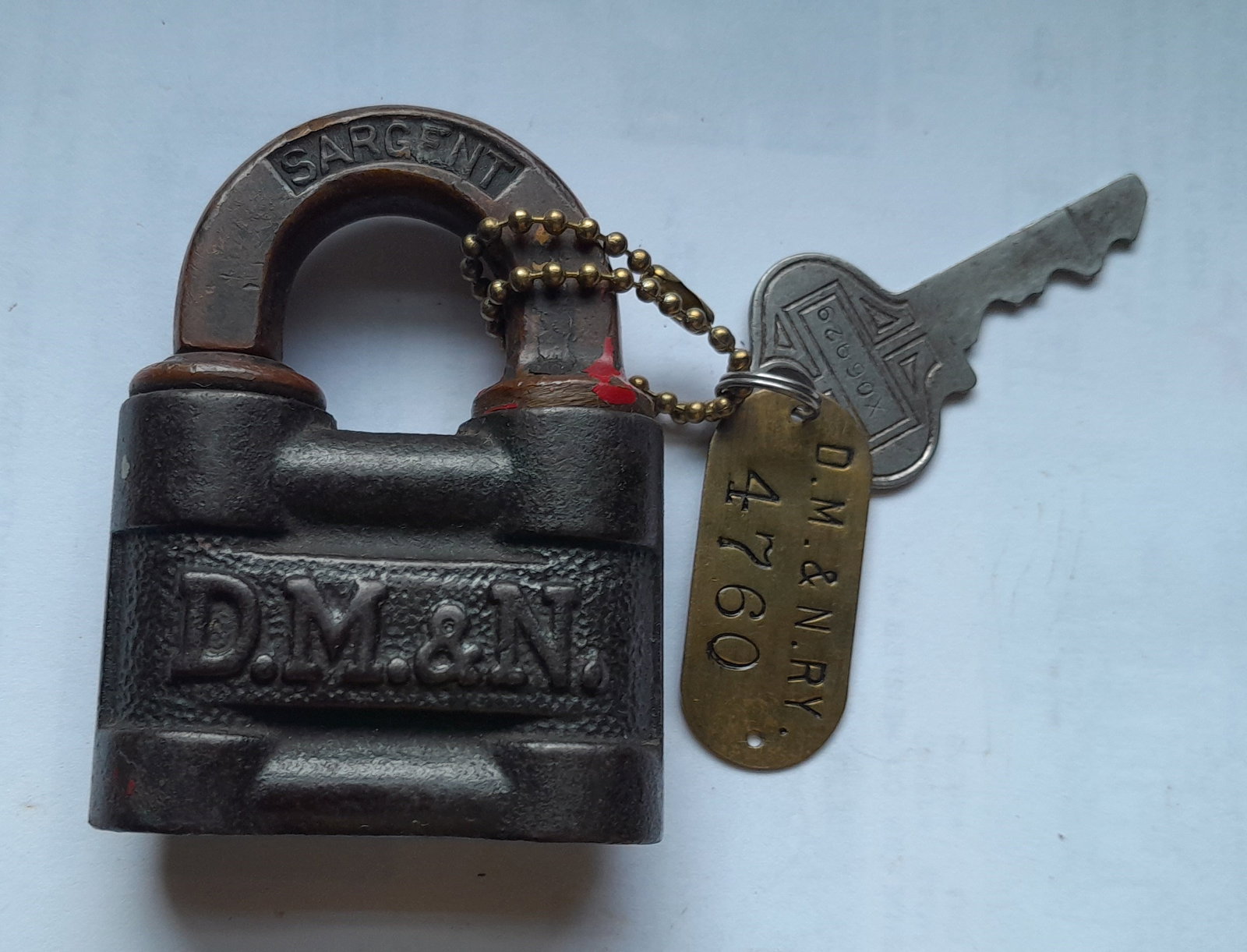Duluth Missabe & Northern Cast Lock by Sargent, Key & Tag included: Cast DM&N initials on both sides of Sargent made lock. Comes with operating key and DM&N tag marked 4760. This name lasted until 1937 when it changed to Duluth Missabe & Iron Range..