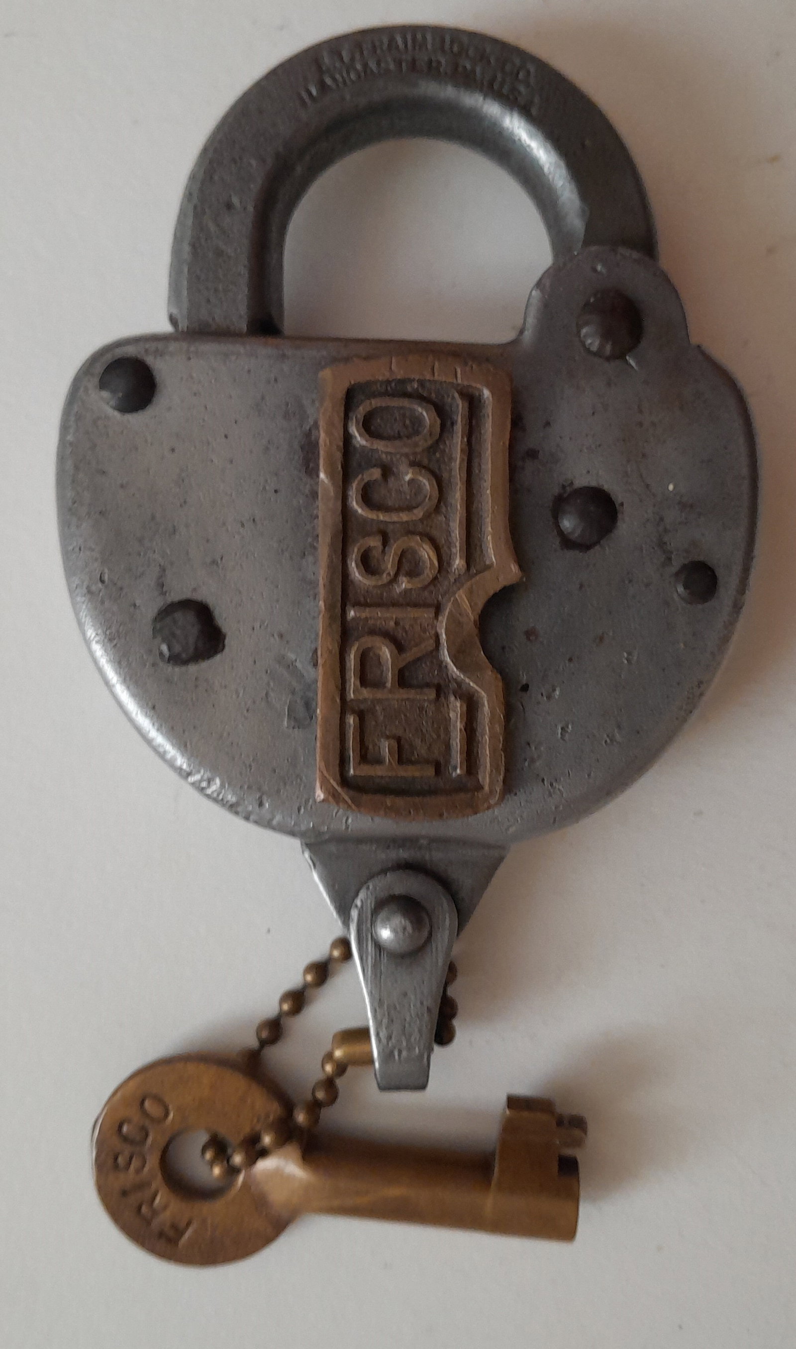 Fraim Lock with FRISCO Cast Brass Dust Cover + Key: An E. T. Fraim stamped shackle with a brass cast dust cover with FRISCO (ST Louis & San Francisco) Nice Patent info stamped on reverse. Key has FRISCO stamped on one side.