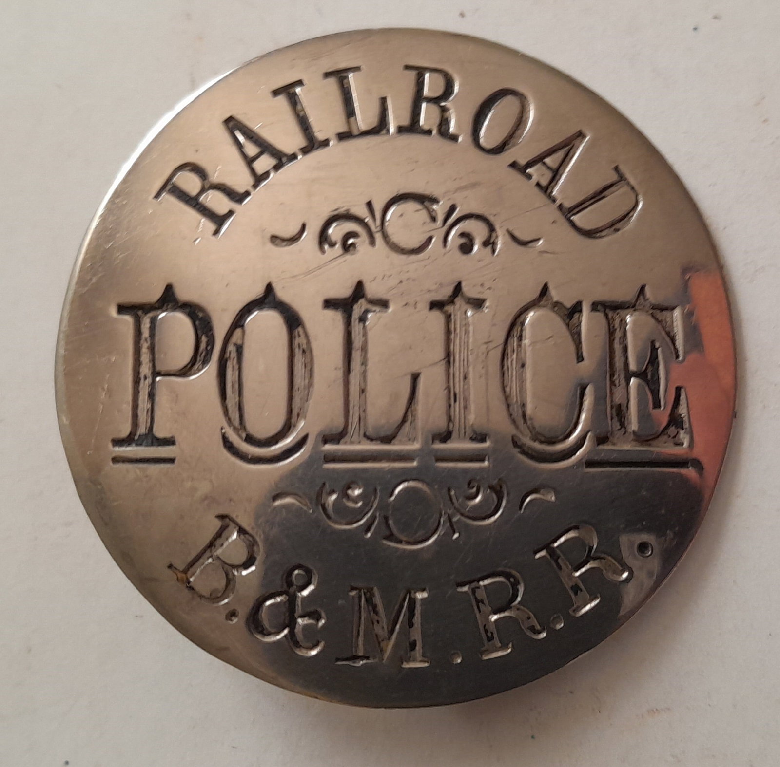 Boston & Maine Railroad Police Badge by John Robbins: A round breast badge made for a patrolman on the Boston & Maine Railroad. It measures 1 3/4" in diameter. John Robbins hallmark on reverse. We have more police badges in this auction and we'll have Ma