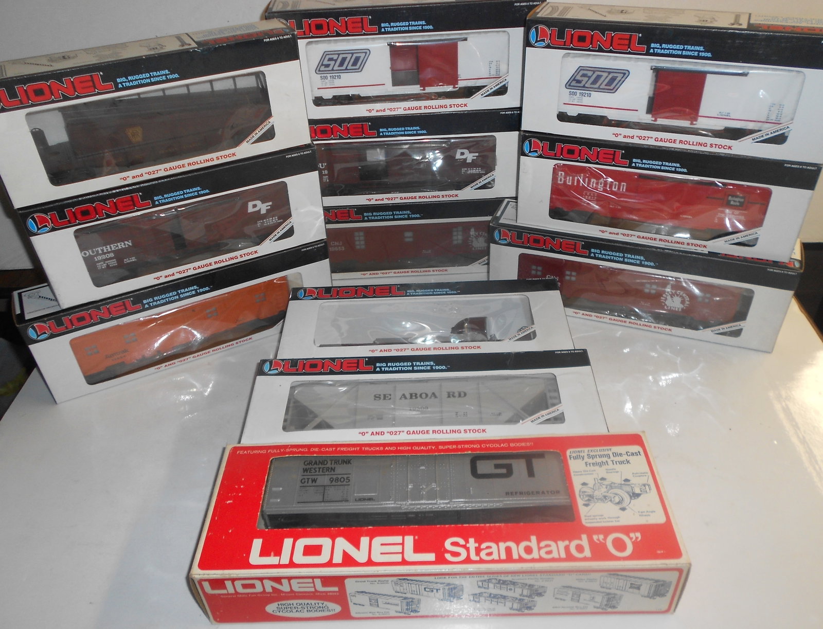 Lionel O Gauge Boxed Freight Cars (12): Lionel boxed freight cars. Various age and types. Some show signs of wear to plastic windows from storage.