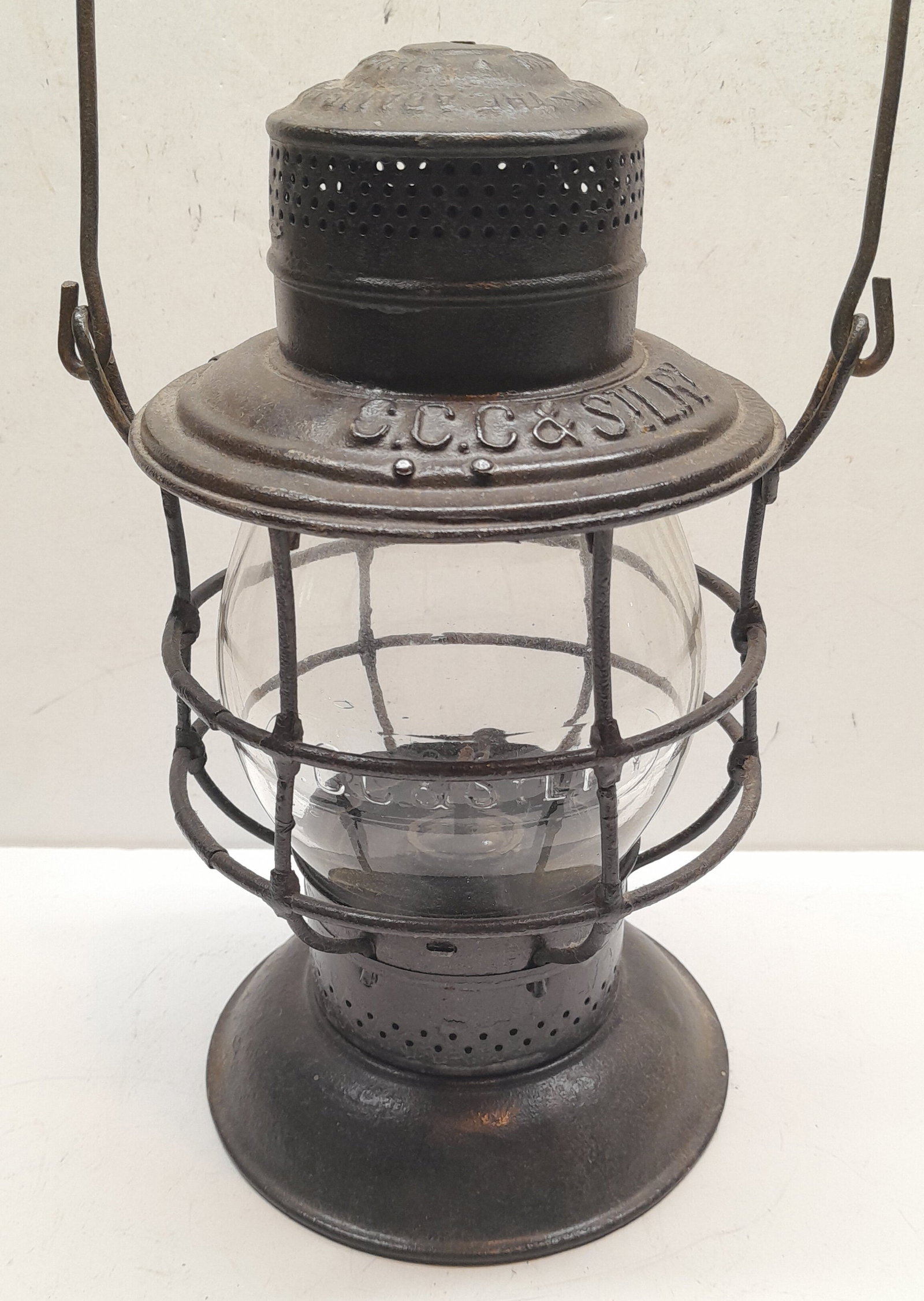 CCC&StLRY Bellbottom Lantern PCC&StLRY Globe: An unusual mismatch with a New York Central controlled line frame with a Pennsylvania controlled line globe. The frame is an 1895 Adams & Westlake bellbottom with "Reliable style (star burst) fount re