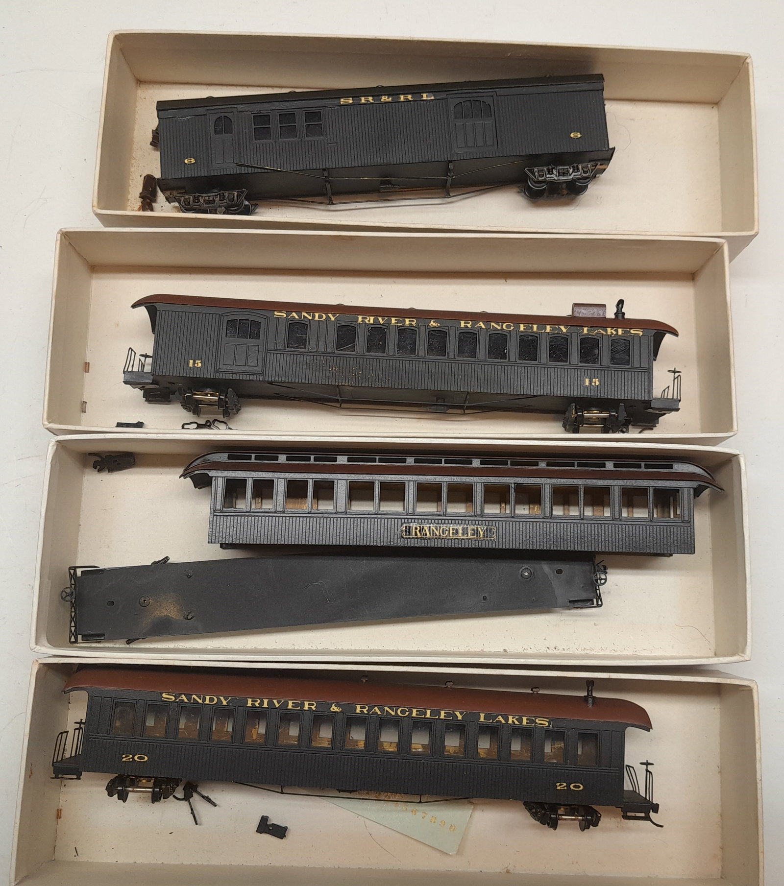 HOn2 1/2 Sango Brass SR&RL Passenger Cars, Decorated: HOn2 1/2 (look like HOn3 trucks to me) of 4 Sandy River & Rangeley Lakes Railroad passenger cars. The coach and Parlor even have window glazing. these are older kits from Japan built by an NMRA MMR. L