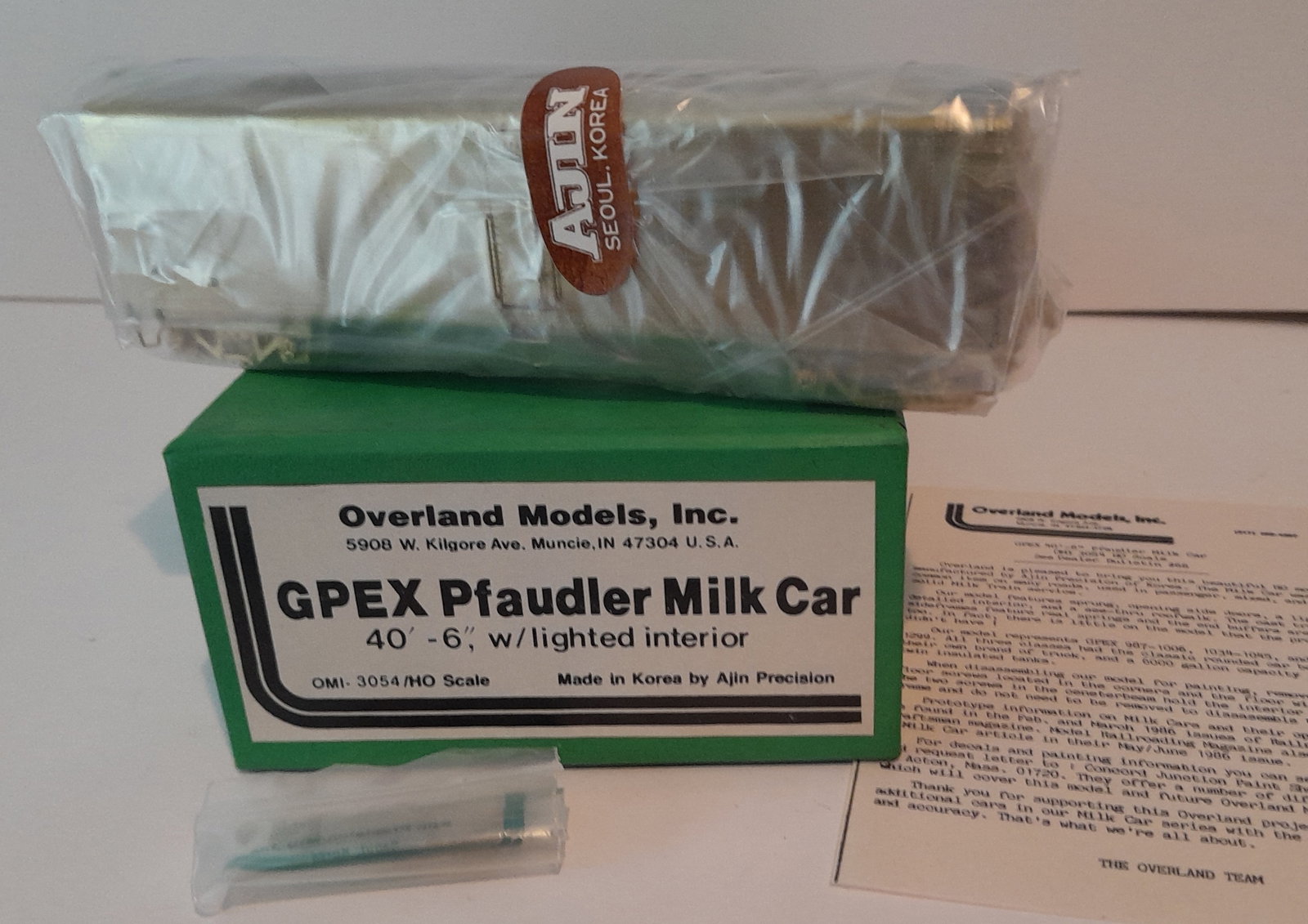 HO Brass - Overland Milk Car OMI-3054: HO scale brass - Overland imported milk car. Made by Ajin in Korea. Still in original factory wrap. Box and foam are fine, OMI bits bag included. OMI paperwork is included. GPEX #3054 40 1/2'. Excelle
