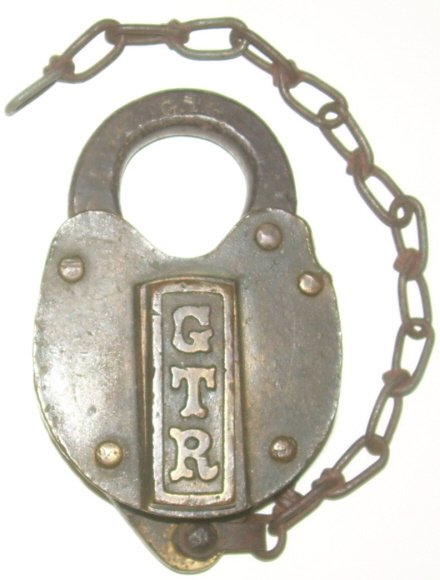 Grand Trunk RY Cast Panel Brass Lock: Grand Trunk Railway Cast Panel Lock. Very fancy lettering on the panel. It comes with a key that works but is not marked. Has a strong dust cover spring. Very Good condition.