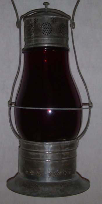 Thompson Utility BB Lantern Red Flashed Globe: An unusual Thompson style lantern with a red flashed barn lamp globe. The intake and vent hole areas along with the ferrule lock down mechanism on the top make this a Thompson lantern. It has just 2 t