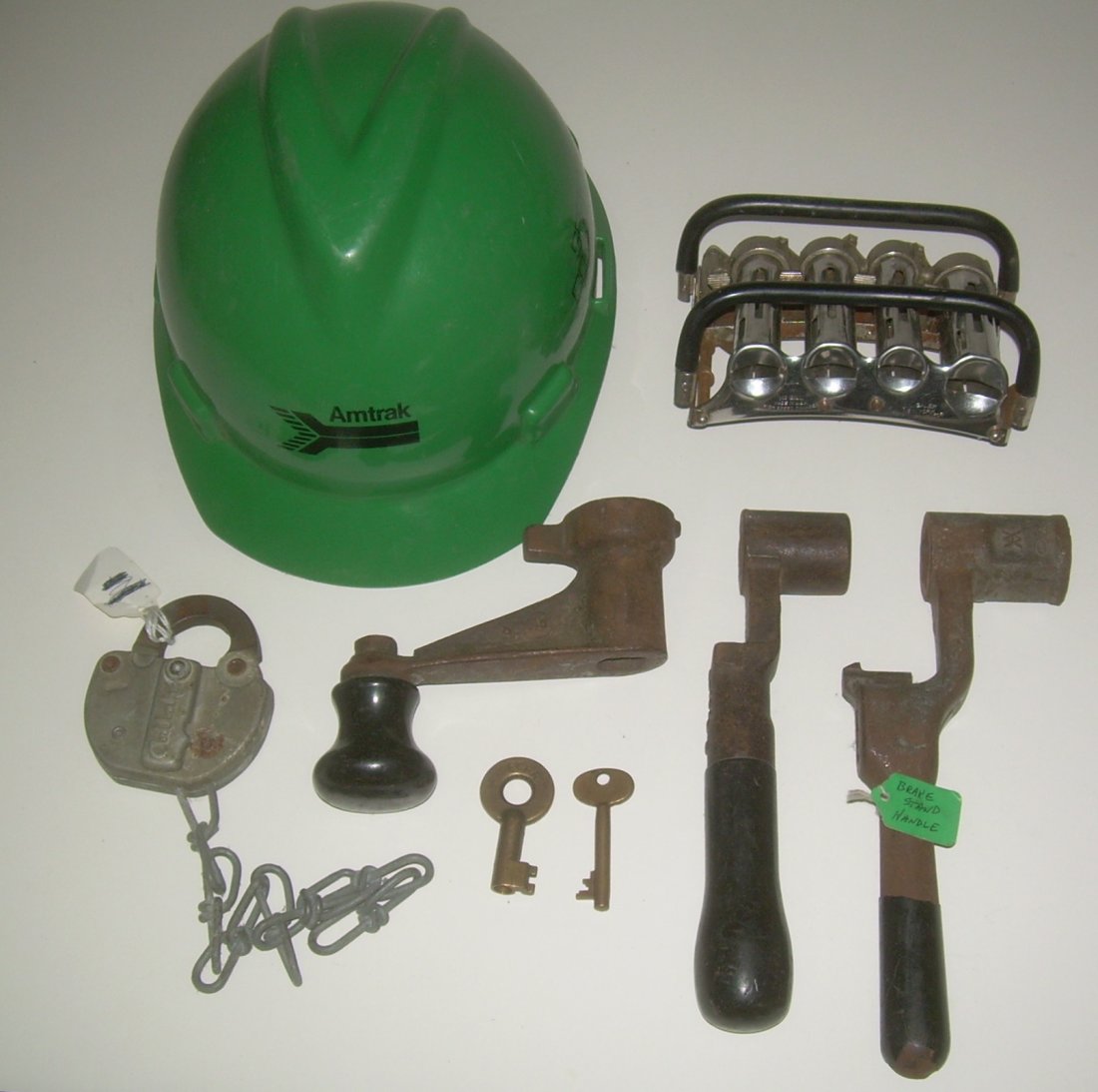 Railroad Employee Related Items (8): Group of 8 railroad employee items: (1) Amtrak hard hat (2) McGill speed changer with 4 tubes (3) Penn Central steel switch lock dated 1974 (4-5) brass keys: PC unmarked (6-8) 3 control handles for br