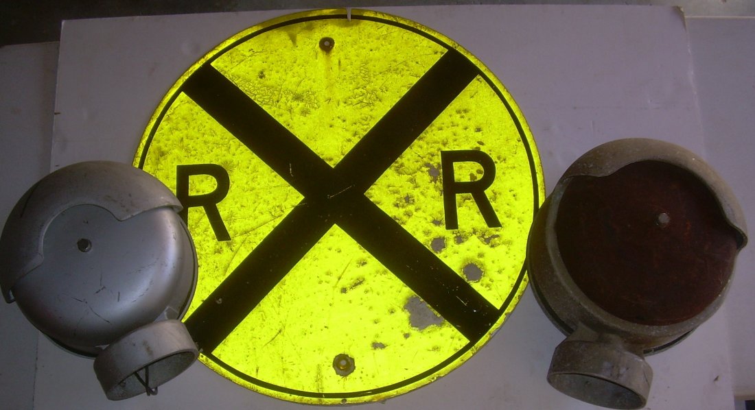 * Railroad Crossing Sign & 2 Crossing Bells: The stamped steel reflective sign is large with a 30" diameter. The sign has two vertical mounting holes. Some peeling/chipped paint. Two bells are included from different manufacturers: (1) SAFETRAN