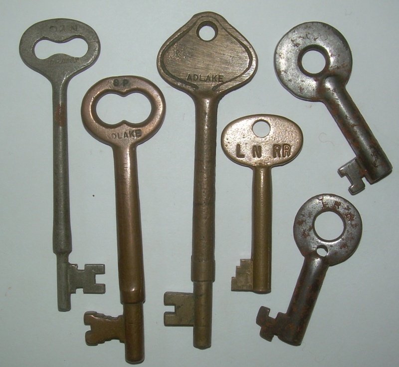 6 Keys - Brass & Steel / Coach & Switch: 6 Keys: (1) NYC Coach in steel (2) SP in Brass (3) large brass ADLAKE (4) L&N telephone box (5) F? RR (Fitchburg? They used some steel keys) drill hole in steel (6) steel switch with heavy wear and ob