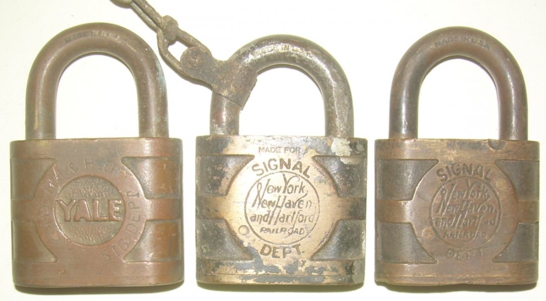 3 New Haven Signal Locks by Yale: 2 different styles: 1 is the stamped lettering around the circle with the straight line lettering. The other has the cast script logo with Yale in fancier lettering. One has an attached chain.
