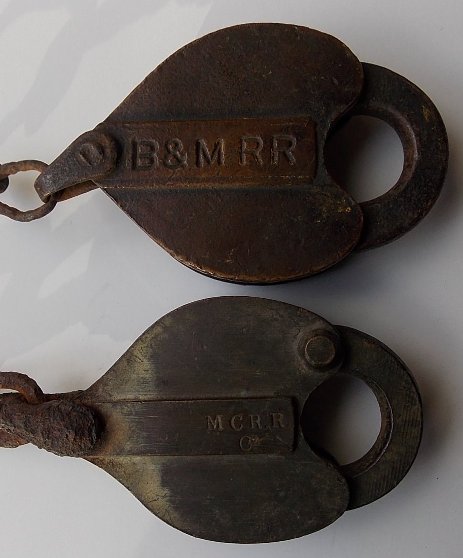 MEC “Car” and Boston & Maine Switch Locks: The first lock is a Maine Central T. Slaight with a “C”ar designation. It has the well known dog-leg keying. Dark original patina. The 2nd lock is a B&M RR cast into the recess of the panel. This 