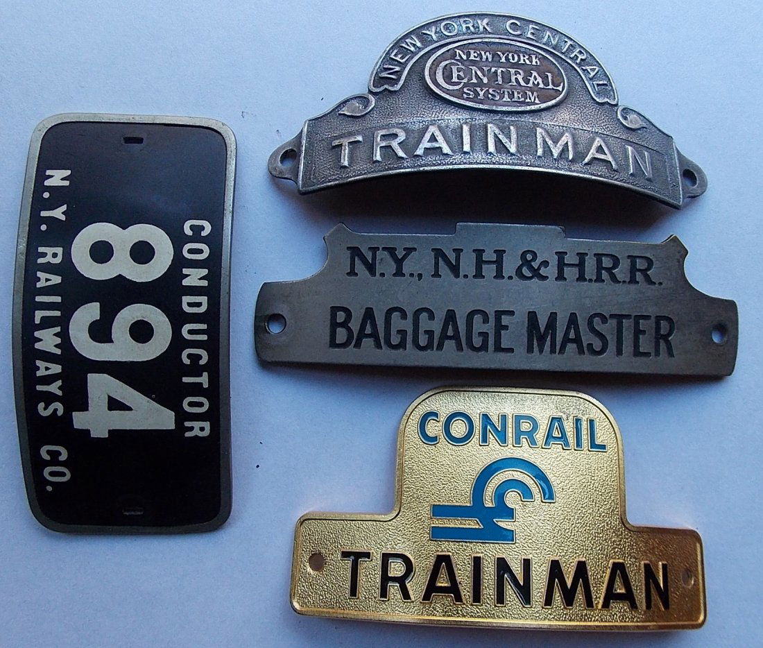 Railroad Hat Badges (4) NYCS NYNH&H CR NYRy: A group of 4 railroad hat badges: (1) New York Central System Trainman – enamel is gone, dome style (2) New Haven Baggage Master – standard notch top (3) Conrail Trainman – standard (4) New York