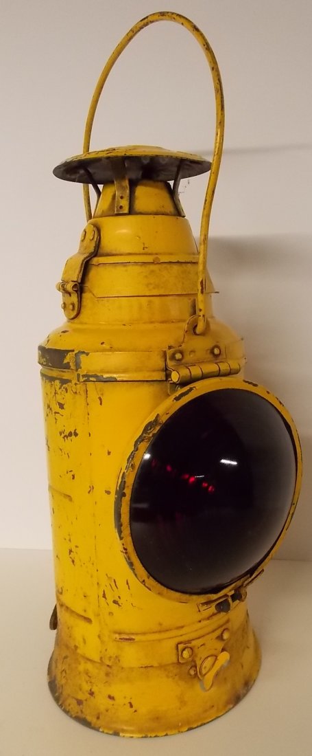 Pennsylvania Lines Railroad Caboose Marker Lamp: A Pennsylvania Railroad Dressel caboose marker with a single red lens and original yellow paint. It has a hinged flip-up door with a PRR Keystone logo beneath the lens and the back also has another PR