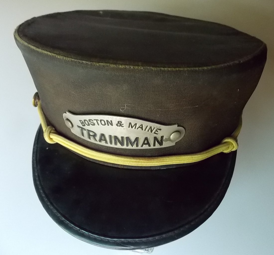 Boston & Maine Railroad Trainman Hat: This hat measures about a size #7. The badge is clearly a Boston & Maine with Trainman as the occupation. The gold braid and Pullman side buttons make this a bit of a mis-match but these things did ha