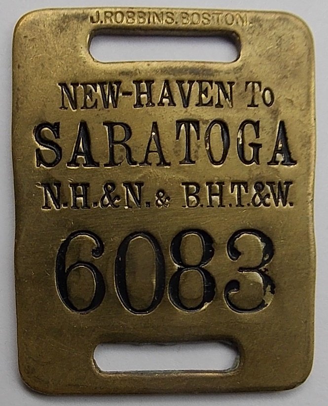 Saratoga New York / New Haven - Baggage Tag: A brass baggage tag used for travel between Saratoga New York and New Haven, Connecticut. The route was over the New Haven & Northampton (Canal Line) and he Boston Hoosac Tunnel & Western. The tag has
