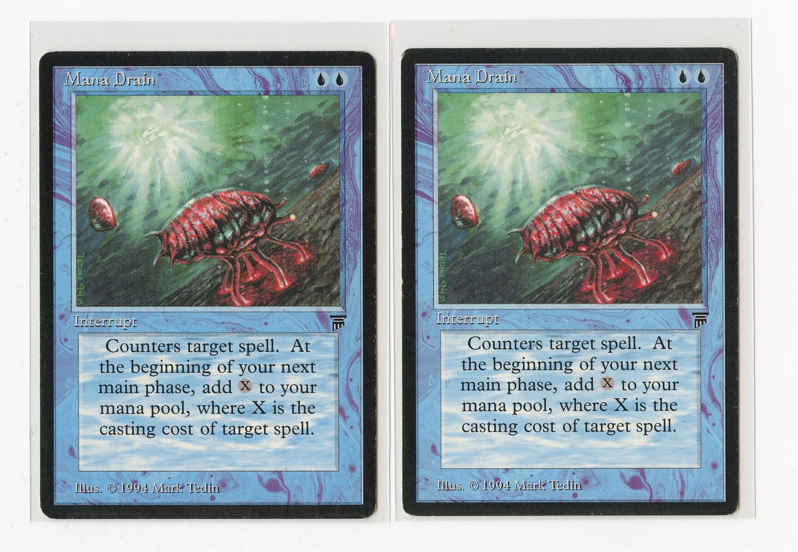 Mana Drain - Legends X2 (LP): Two copies of Mana Drain from Legends, both in Light Played condition. These cards demonstrate notable surface wear/hazing, alongside border dings and wear, with some surface dents and scratches also