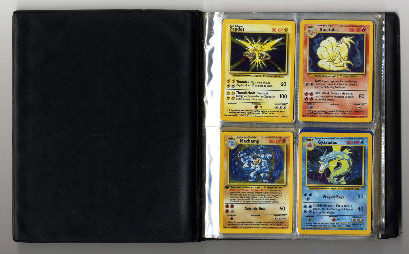 Base Set Partially Complete Set + Original Binder: A partially complete Base Set, including x4 holos and approximately 100 other cards (some duplicates included). This is very much so a childhood collection, and as such the original WOTC binder has so
