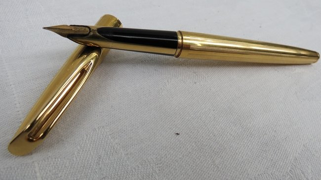 A Waterman fountain pen with 18k gold nib and gold barr: A Waterman fountain pen with 18k gold nib and gold barrel, pen no. K69498, within wooden case.