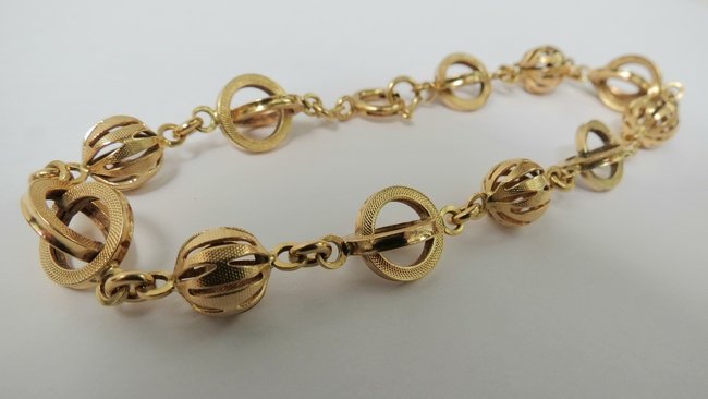 A 14ct gold bracelet, formed of linked hoops and pierce: A 14ct gold bracelet, formed of linked hoops and pierced balls, 12.1g.