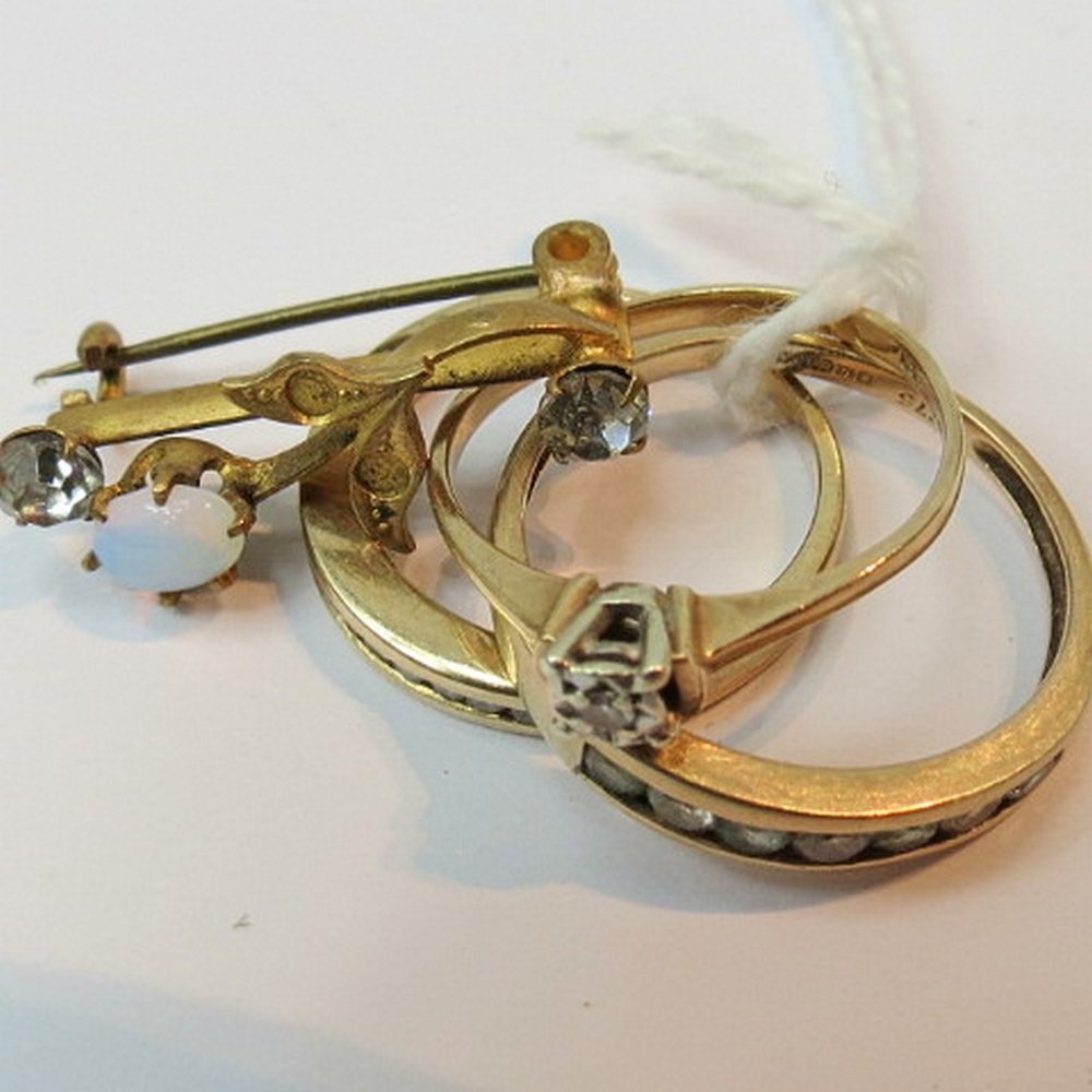 A solitaire diamond ring, illusion set i: A solitaire diamond ring, illusion set in a 9ct gold band, together with a quarter hoop eternity ring, another line set dress ring and a brooch, 3.8g