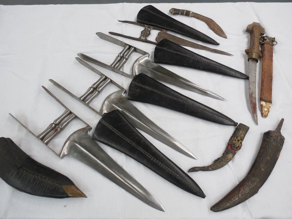 A Katar, or punching dagger, with black leather: A Katar, or punching dagger, with black leather scabbard together with three other similar and four other Middle Eastern knives.