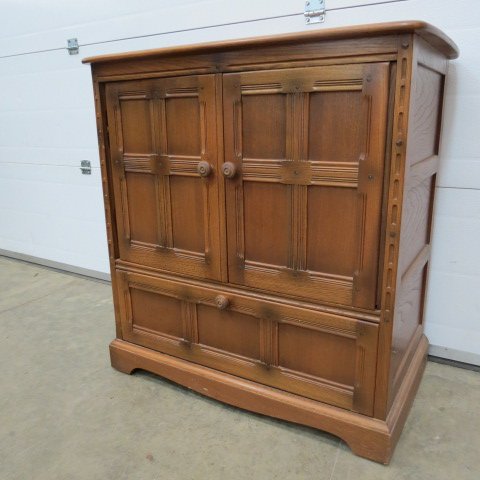 An Ercol light oak television cabinet, fitted with a: An Ercol light oak television cabinet, fitted with a pair of panel doors above a drawer. 91cm wide.