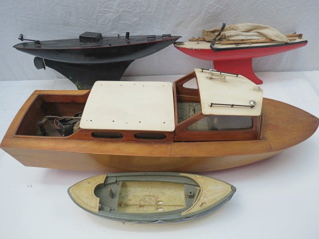 A radio controlled model launch with clear lacquer hull: A radio controlled model launch with clear lacquer hull and deck with cream roof 52cm overall, also a ships lifeboat, plastic and two small pond yachts.AF.
