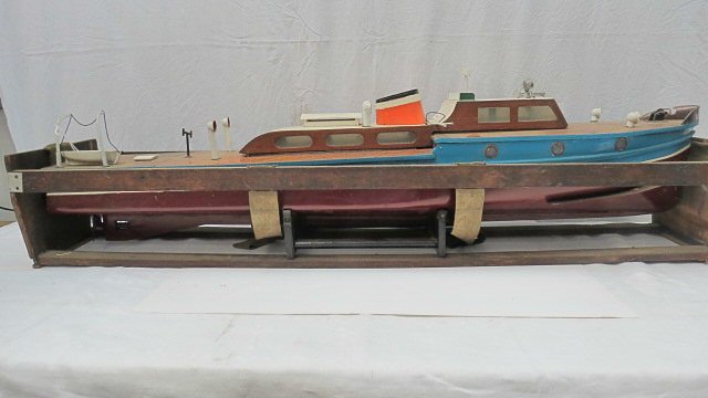 A scale model of a large motor launch 'Beta', hand: A scale model of a large motor launch 'Beta', hand built in wood complete with varnished deck and port holes, lifeboat, electric motor and carrying cradle. 112cm.