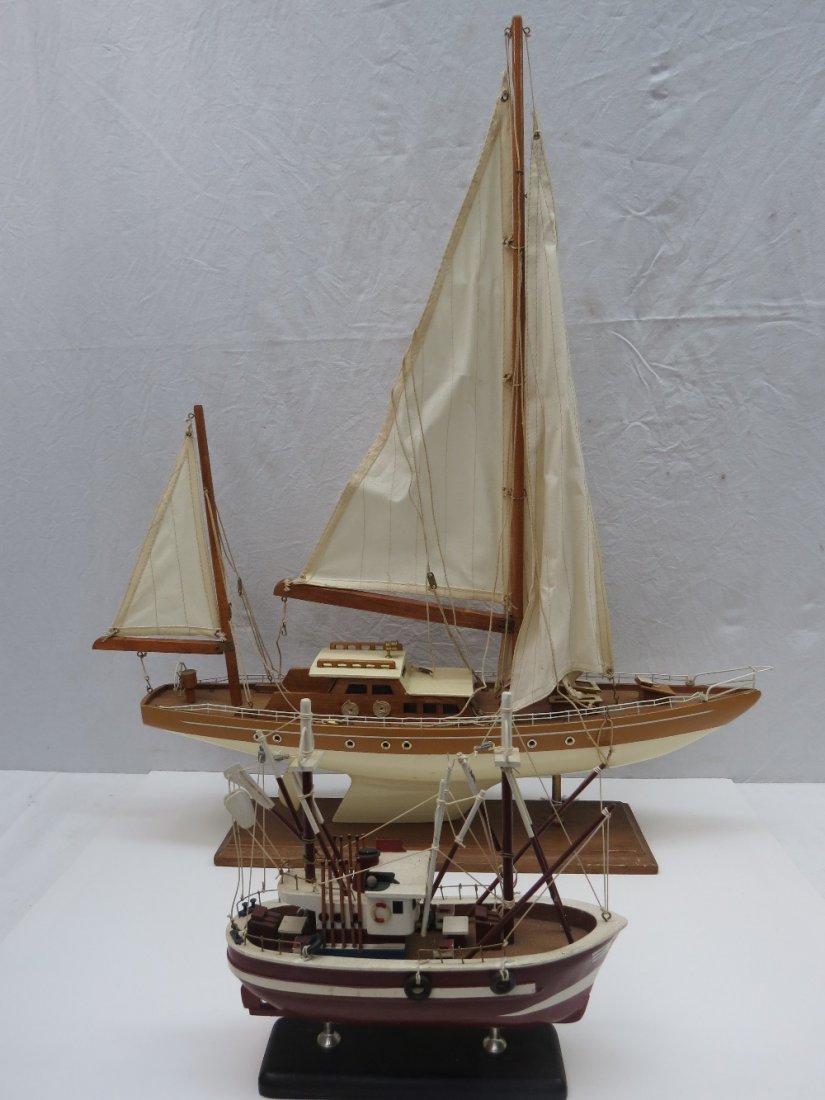 A late 20thC model yacht and another: A late 20thC model yacht with cream hull and mustard above the water line, 57cm long, together with a smaller scale model of a fishing vessel.
