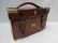 A leather case with brass corners, oval and shield