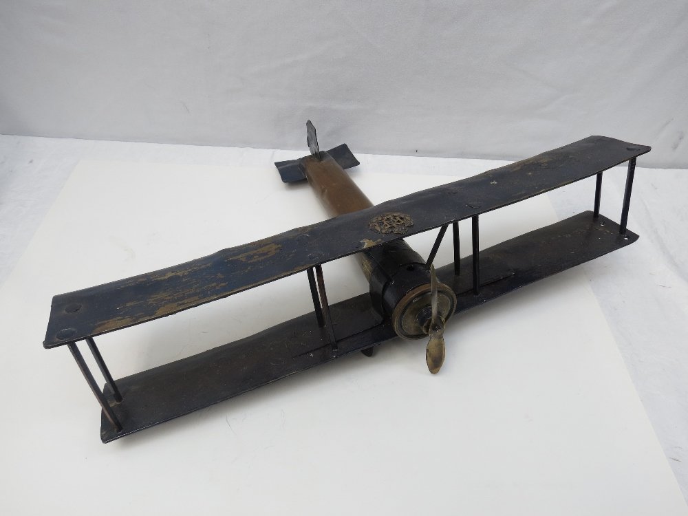 WW1 RAF trench art, a large biplane model created from: WW1 RAF trench art, a large biplane model created from shell case fuselage and shell case fragments circa 1920's, of soldered and riveted construction with applied RAF cap bade to upper wing and penny