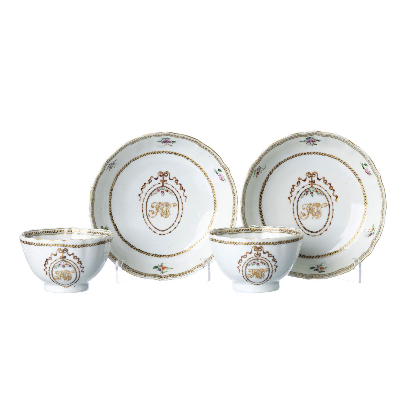 Pair of Chinese porcelain monogrammed tea cup and saucer, Qianlong: China, Qianlong, gummed with famille rose and gold enamel decoration, monogrammed cartouche in the center and floral motifs. Wear on the gilding, minor flaw on the base of a glass. Dim.:12,5cm.