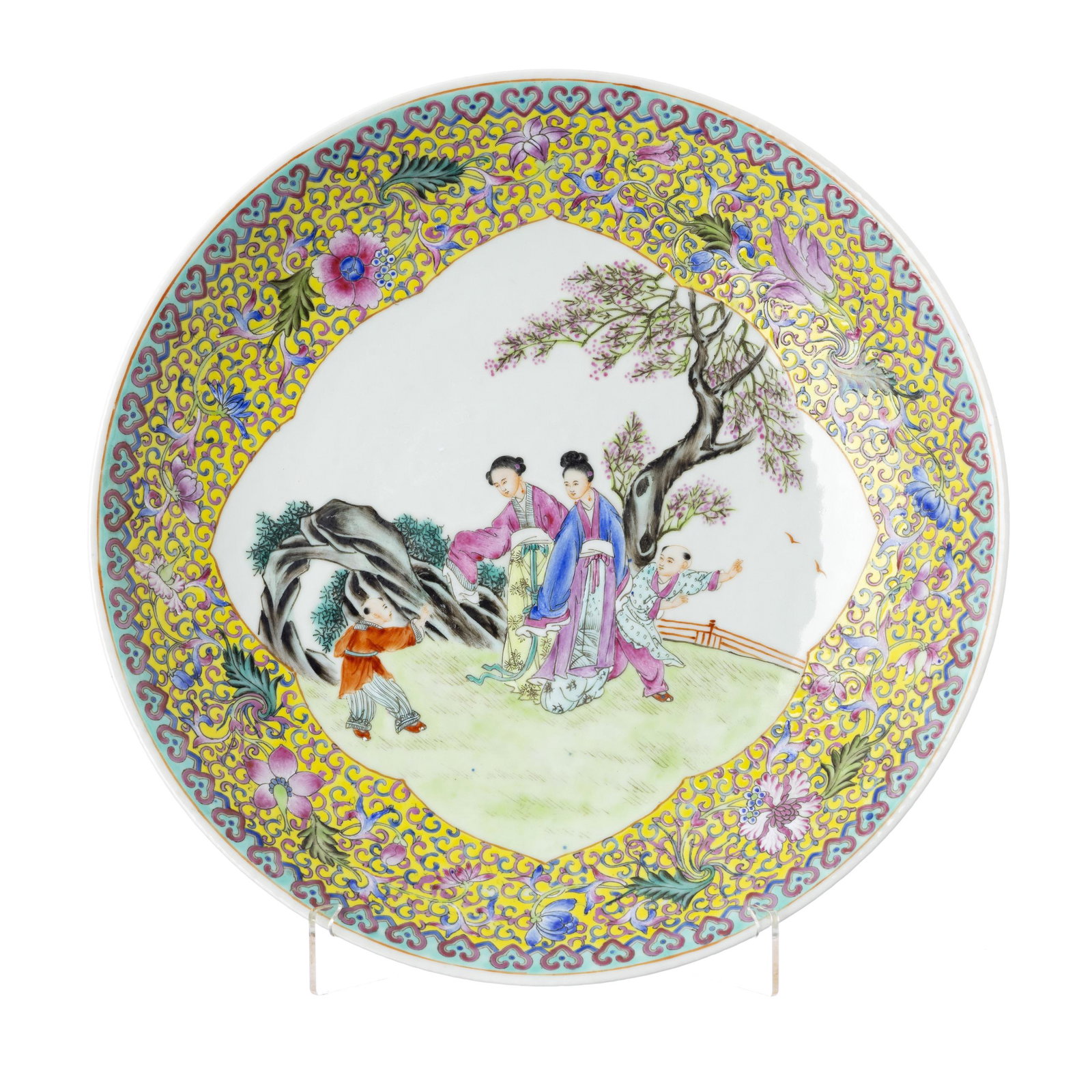 Plate 'figures in landscape' in Chinese porcelain, Republic: China, Republic, polychrome decoration in famille rose enamels, with female figures with children in a landscape, yellow background with flowers and lotus windings, ruy frieze. Mark on the base. Signs