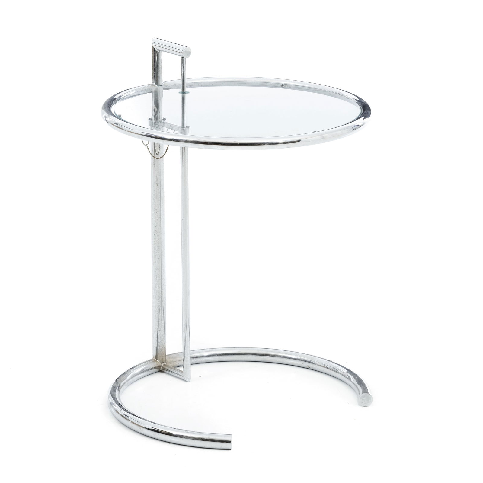 Style of EILEEN GRAY - Side table: Italy, c.1980, side table in chromed metal, adjustable in height according to model E1027 by Eileen Gray, curved structure and round top in transparent glass. Signs of use. Max dim:90cm.