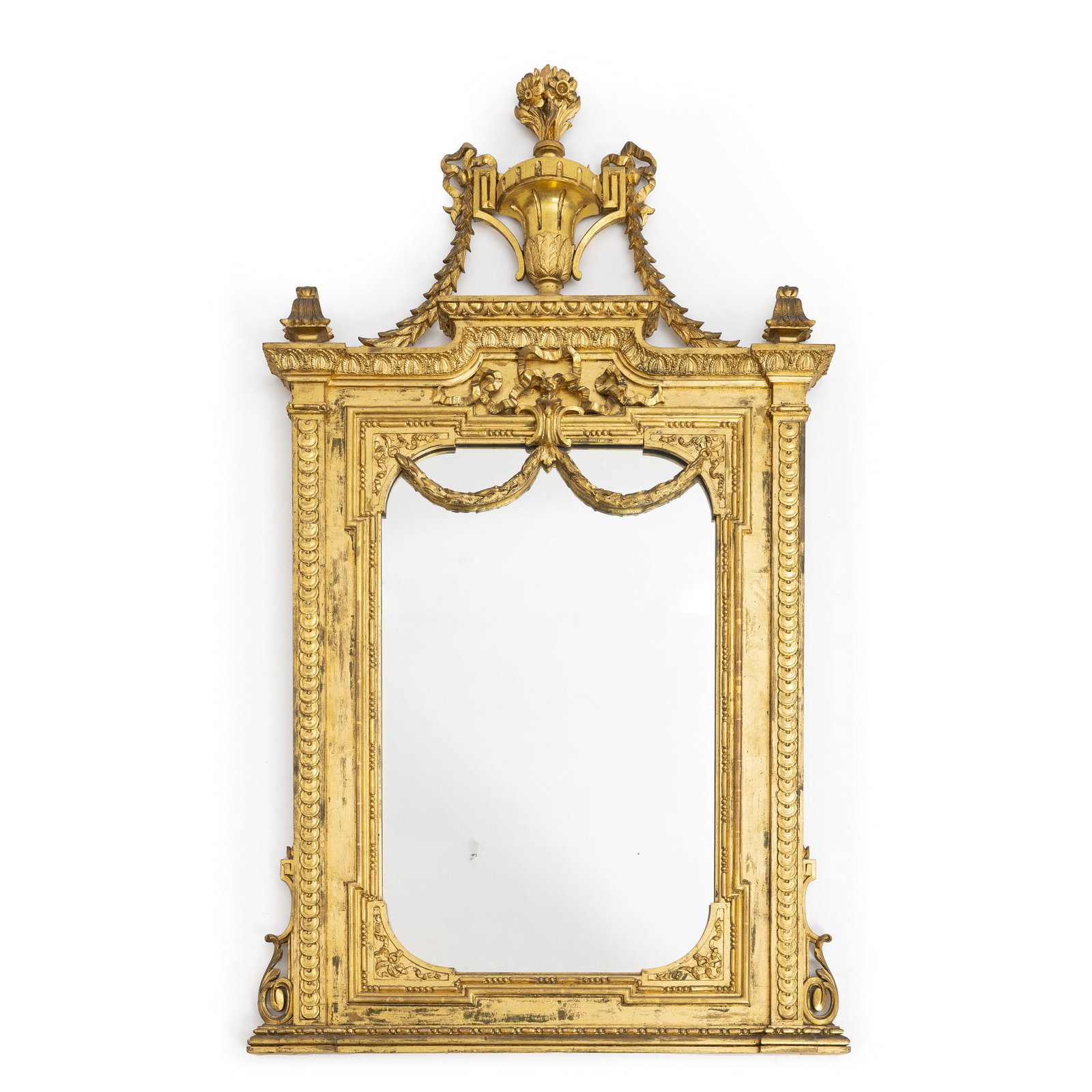 Napoleon III giltwood mirror: France, 19th century, carved and hollowed wood burnished in gold, surmounted by urn, garlands and plant motifs. Signs of wear, small faults. Dimensions: 187x110 cm