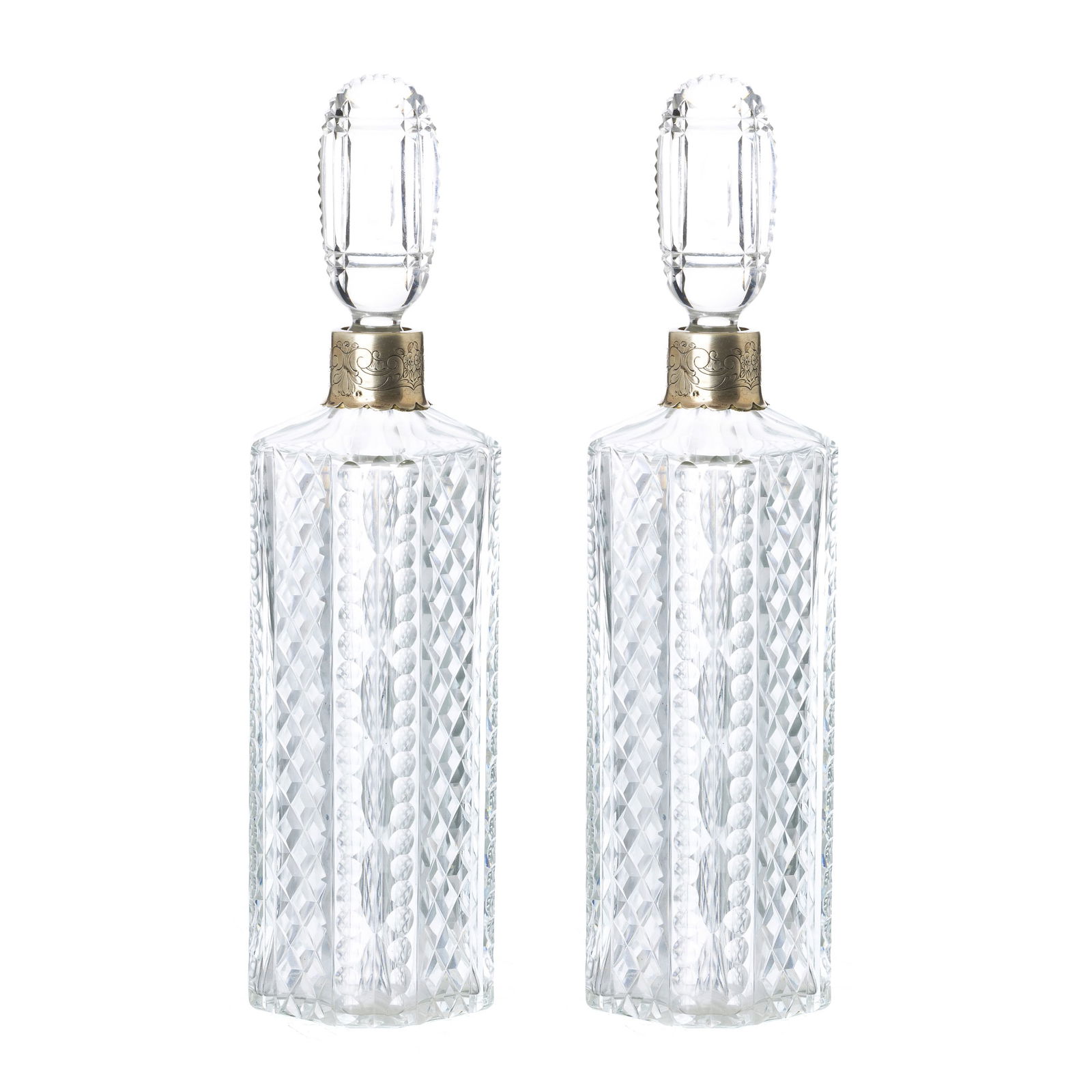 Pair of crystal and silver bottles: Portugal, c.1960, in cut crystal with silver applications, eagle hallmark 833 (1938-1984), goldsmith's mark, with incised decoration of flowers, scrolls and acanthus leaves. Signs of use, damaged lids