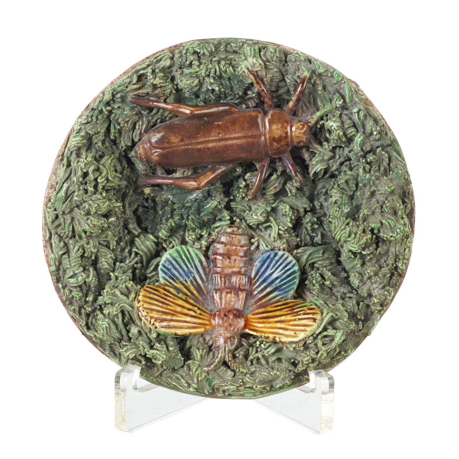 'Insects' earthenware plate by Manuel Mafra: Caldas earthenware, made by Manuel Mafra, with polychrome relief decoration depicting a grasshopper and a butterfly on moss. Marked. Signs of use. Dim.: 11.5cm.