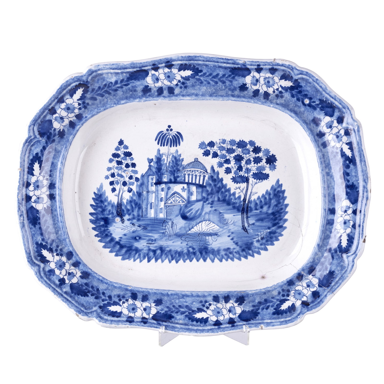 Portuguese figural earthenware platter: Portuguese earthenware, attributed to Miragaia, 19th century; decorated in blue with a rural landscape; scalloped edge with floral motifs on the rim. Signs of use, minor chips. Dim.: 46cm.