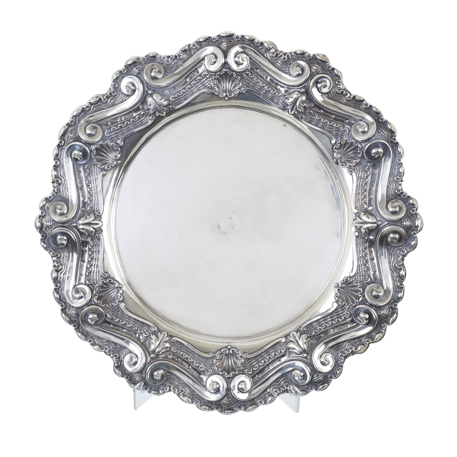 Large chased Silver charger: Portuguese silver, 833 eagle hallmark (1938-1984); raised decoration featuring scrollwork, volutes and plant motifs. Signs of use. Approx. weight: 1315g. Dim.: 50cm.