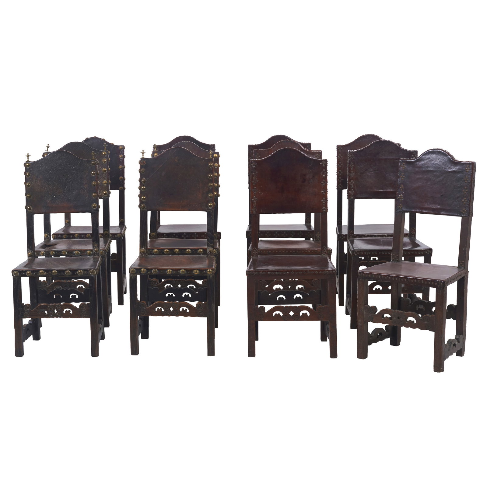Set of twelve chairs with leather and nails: Portugal, 17th century, carved chestnut; seats and backrests in embossed leather with various brass metal studs. Signs of use and wear; small tears. Dim,: 107x45.5x38.5cm.