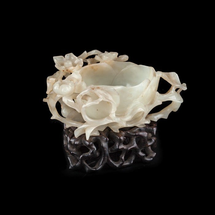 Brushwasher jade celadon: China 20th Century, Minguo period, celadon jade carved and cast, forming a cup and flowers, wooden base leaked. Dim.: 11cm.
