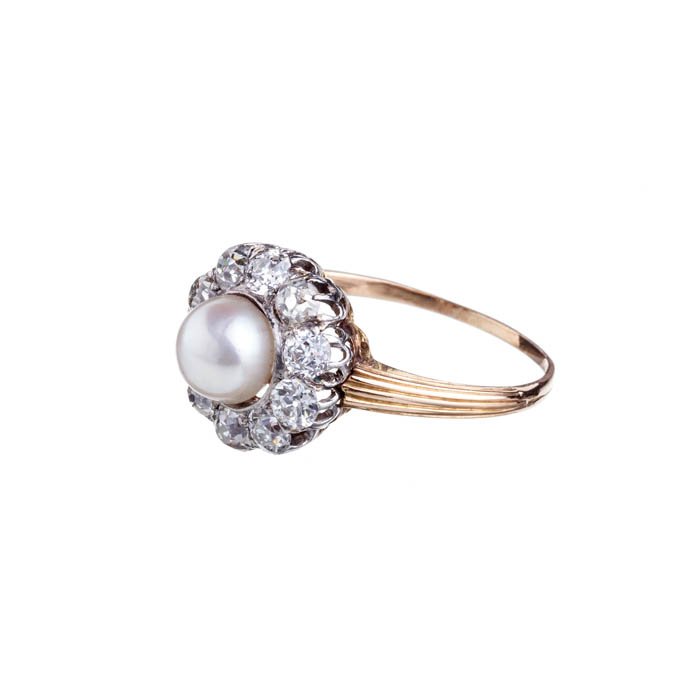 'Rosette' ring with diamonds: Gold and silver, studded with a pearl and ten diamonds. Approximate weight:5,6grs. Dim.:3cm; diam.:2,2cm.