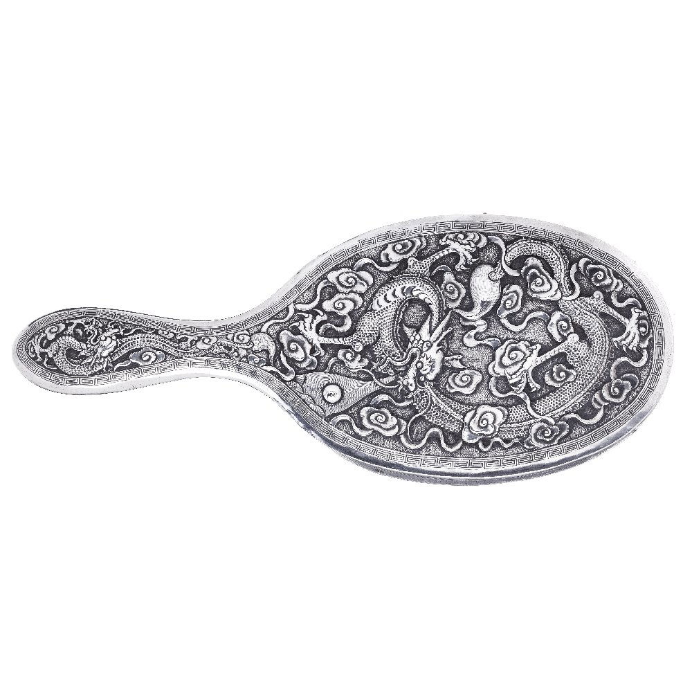 Hand Mirror 'Dragon' in Chinese silver: China, 19th Century, carved silver, plant decoration with dragon amongst ruyi and Greek relief. Signs of use. Dim:. 26cm.