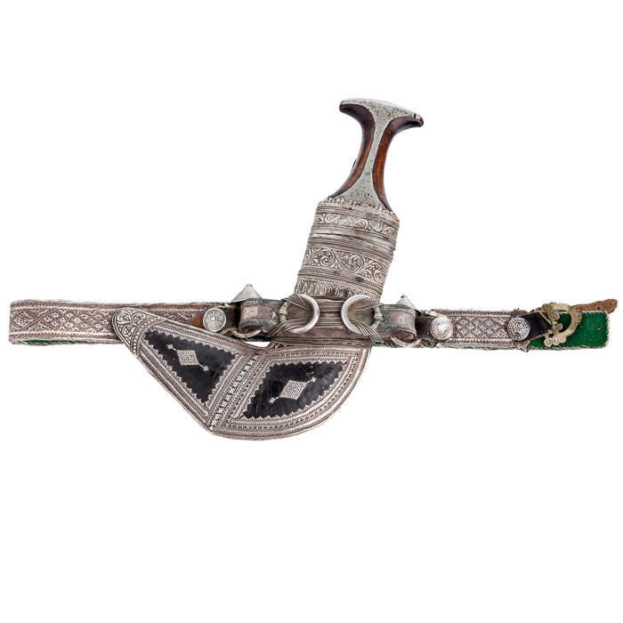 Khanjar dagger, Oman: Wood handle and metal sheath curved leather and silver buckle decorated with silver wire, Oman, 19/20th Century. Signs of use. Dim:. 30cm.