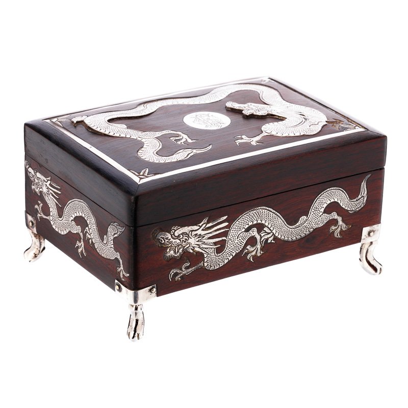 Box in tamarind wood and Chinese silver: China, 19th/20th century, box in tamarind, silver applications 'dragons', marked 'MH90', attributable to Man Hing, Macau, monogram on the lid. Signs of wear, small flaws. Dim.:7x13,3x9cm.