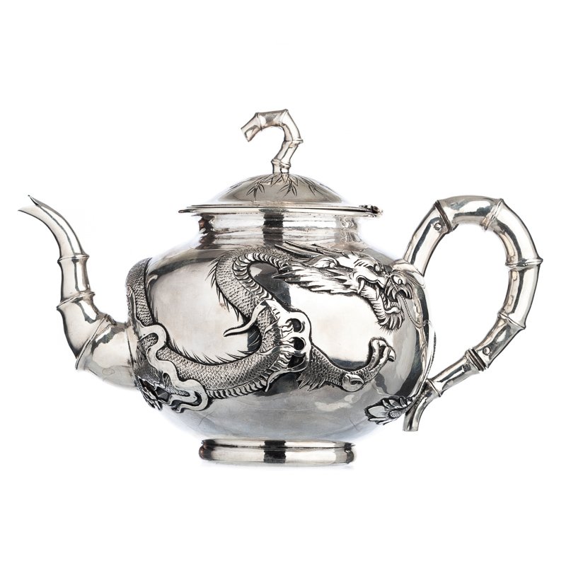 Tea pot 'dragon' in Chinese silver: China, 19th/20th century, silver marked 'WH' attributable to Wang Hing, ideogram and '90', dragon relieved decoration, handle, spout and lid handle shaped as bamboo. Signs of wear. Weight aprox.:707gr