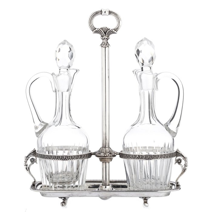 Cruet in silver: Cruet in European silver without marks, relieved decoration with acanthus leaves, two glass flasks, lapidated decoration. Approx. weight silver:324grs. Dim.:25cm.