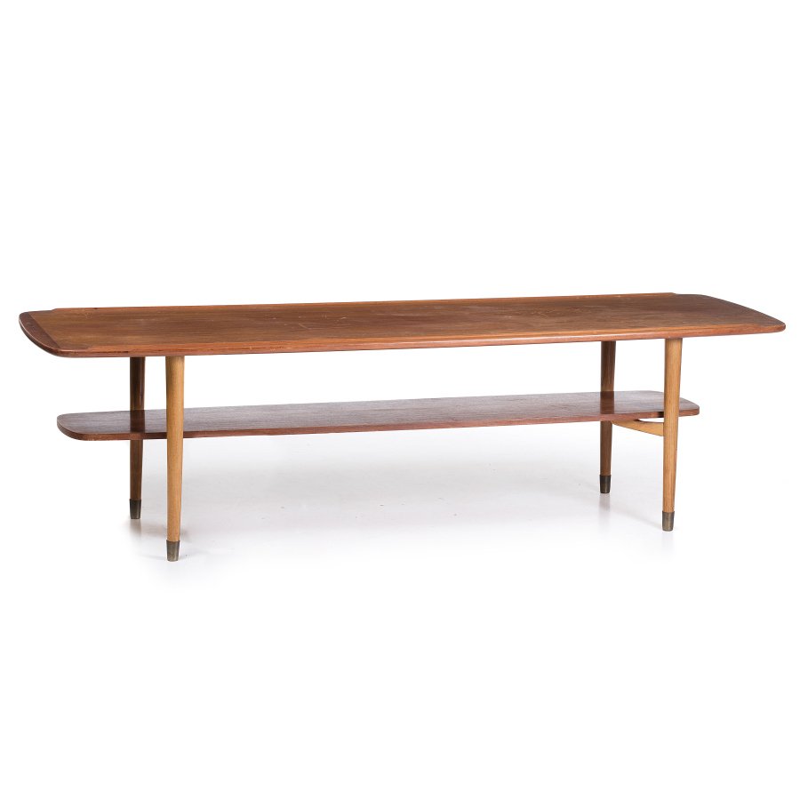 HANS WEGNER (1914-2007) (attr.) - Large coffee table: Denmark, c.1950, in teak wood, with carved border, two levels, feet with application in brass. Dim.: 50x57x178cm.