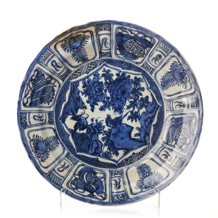 Plate 'Kraak' in Chinese porcelain, Wanli: China, Ming Dynasty, Wanli Reign (1563-1620), decoration in cobalt blue, bird and flowers, border with reserves alternating auspicious symbols with flowers, decorated back. Small restoration on the bo