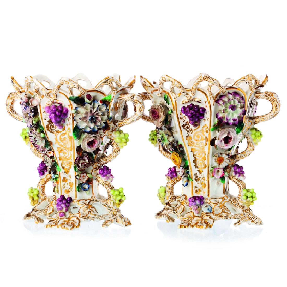 Two vases in porcelain, Jacob Petit: Pair of vases in porcelain, molded and pierced, French, 19th century, relieved decoration, polychrome and gold, 'flowers and grapes', marked 'JP'. One has defects. Dim.:18,5cm.