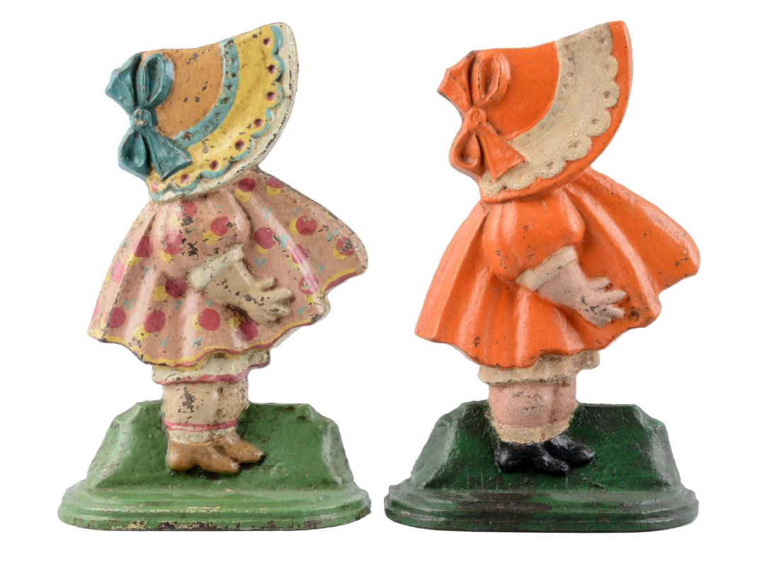 Lot Of 2: Cast Iron Sunbonnet Girls Doorstops.: Variation in colors. Sunbonnet girls with bow in bonnet. (Excellent). Each : 9 -1/2" x 6".